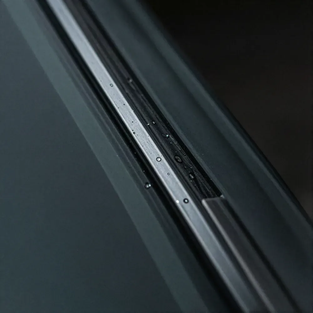 Close-up of the edge of a newly fitted vehicle window seated against its rubber molding